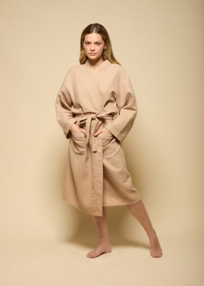 Robe curto unissex em algodão bege com textura canelada, cinto do mesmo tecido, bolsos frontais e mangas longas