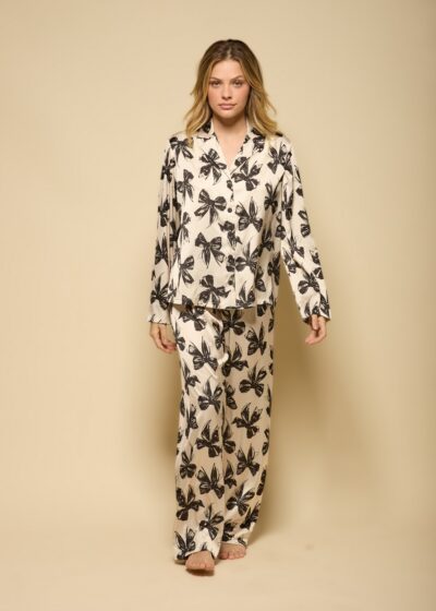 Conjunto de pijama feminino em cetim bege com estampa de laços pretos, camisa de manga longa com botões e calça reta